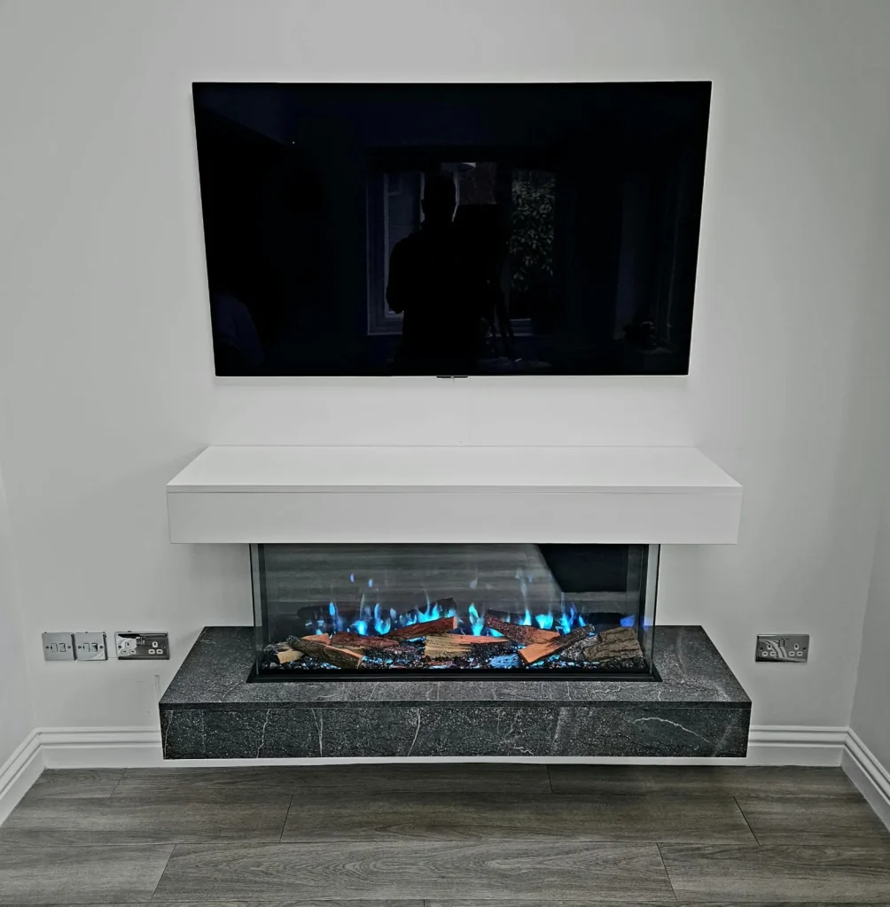 A wide blue-flame fire below a white mantel and television in a contemporary media wall.