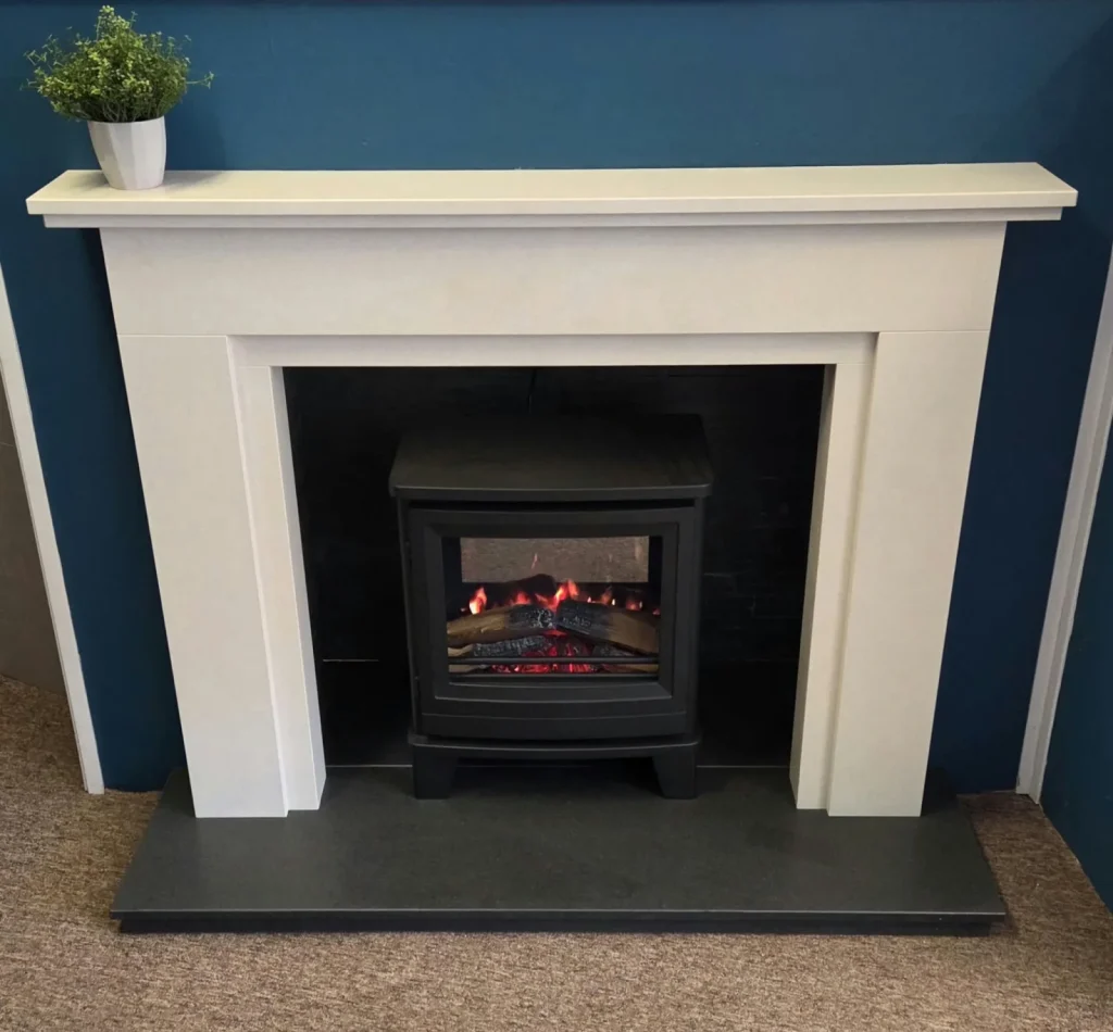 A white mantel and black stove against a deep teal wall, set on a dark hearth.